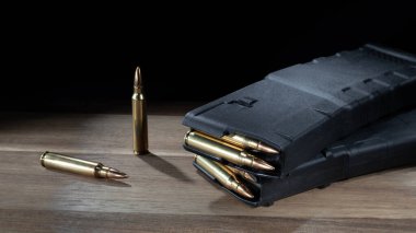 Polimer AR-15 şarjörleri 30 şarjörle doldurulmuş. Her biri bir masanın üzerinde, yanında iki tane yedek mermi var..