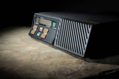 Karanlık bir ortamda, bir kayanın üzerindeki VHF bandı için amatör telsizdeki düğmeyi tara ve izle..