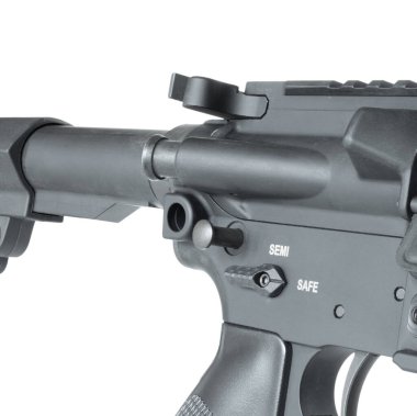 Takedown pin in the lower receiver toward the back partially pushed out to begin field stripping isolated in a studio shot. clipart