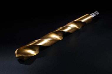 Koyu arkaplanda altın rengi sert kaplama ile tabandan daha geniş matkap ucu.