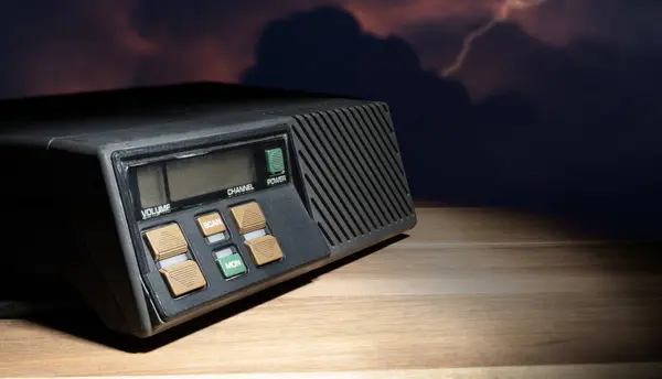 stock image Lightning striking on storm clouds behing a two-way radio on a wood table.