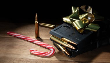 Yüksek kapasiteli AR-15 şarjörleri altın bir Noel yayının altında, masada fazladan ammon ve şeker kamışı var.. 