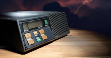 Tahta bir masanın arkasındaki bulutlardan yıldırım gibi gelen kısa dalga alıcısı..