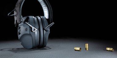 Fotokopi alanı olan karanlık bir arkaplanda çekim yapmak için elektronik işitme korumanın yanındaki boş pirinç.