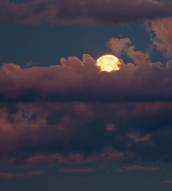 Gün batımından hemen sonra pembe ve mor bulutlar arasında dolunay geliyor.. 