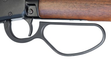 Tahta kaplı tüfeğin geniş kollu kolu beyaz arka planda izole edilmiş görüntüde tam uzunlukta tetik ve çapraz cıvata güvenliğiyle görülüyor..