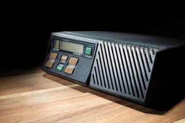 Amatör radyo, VHF frekanslarında, karanlık bir odada, ahşap bir masada kullanılıyor..