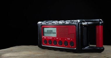 Uzayı, yeniden şarj edilebilir vuruculu, güneş ve el kolu desteğiyle siyah ve kırmızı hava durumu radyosunun yanına kopyala ve LCD ekranında şiddetli bir fırtına uyarısı göster.