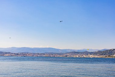 Denizden Cannes 'ın görüntüsü, iki helikopter sahilin üzerinde uçuyor. Vue sur Cannes milletvekili la mer, deux helikopterler survolent la cote.