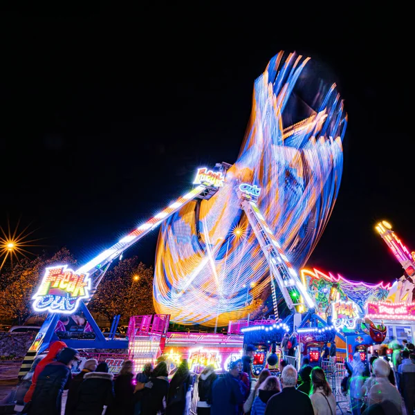 Fransa, Dijon, 2023-11-11. Gastronomik fuarın yanındaki lunapark, sansasyonel cazibeler. Aydınlatılmış uzun trenlerin montajı. Çılgınca