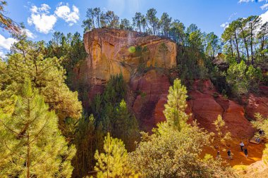 24 Eylül 2025 'te Fransa' nın Vaucluse Bölümü 'ndeki Roussillon' da, kan ve altın renkli yolların ve uçurumların jeolojik manzarası olan Sentier des Ocres 'in bulunduğu yer. Güneşli bir Provencal günü sunuyor bir dekoru toprak ve gök mavisi.