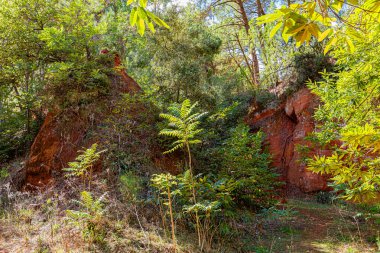 24 Eylül 2025 'te Fransa' nın Vaucluse Bölümü 'ndeki Roussillon' da, kan ve altın renkli yolların ve uçurumların jeolojik manzarası olan Sentier des Ocres 'in bulunduğu yer. Güneşli bir Provencal günü sunuyor bir dekoru toprak ve gök mavisi.
