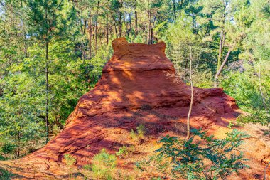 24 Eylül 2025 'te Fransa' nın Vaucluse Bölümü 'ndeki Roussillon' da, kan ve altın renkli yolların ve uçurumların jeolojik manzarası olan Sentier des Ocres 'in bulunduğu yer. Güneşli bir Provencal günü sunuyor bir dekoru toprak ve gök mavisi.