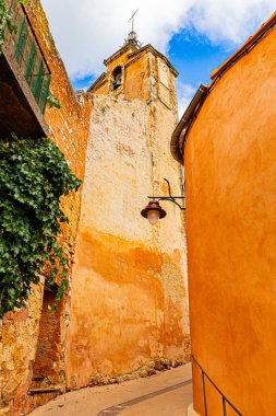 Roussillon 'un 24 Eylül 2025' te Fransa 'nın Vaucluse departmanındaki sokak, mimari ve renkleri. Ön cephenin düşük açılı görünümü.