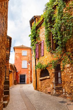 Roussillon 'un 24 Eylül 2025' te Fransa 'nın Vaucluse departmanındaki sokak, mimari ve renkleri. Ön cephenin düşük açılı görünümü.