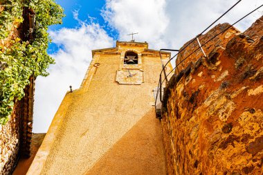 Roussillon 'un 24 Eylül 2025' te Fransa 'nın Vaucluse departmanındaki sokak, mimari ve renkleri. Ön cephenin düşük açılı görünümü.