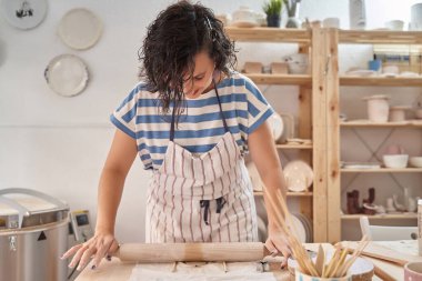Çömlek atölyesinde, önlük giymiş çömlekçi bir kadın. Sanat, sanat ve hobiler konsepti.
