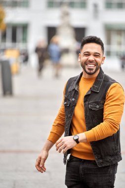 Man smiling while standing on the street. Positivity concept.