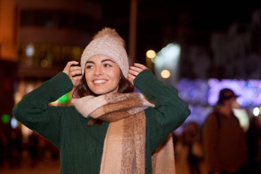 Woman wearing winter clothes while standing outdoors on the street. Winter season concept.
