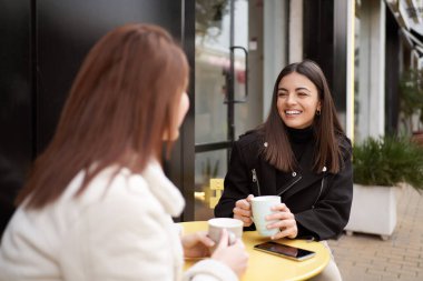 Bir kafede kahve içerken gülümseyen bayan arkadaşlar. Arkadaşlık kavramı.