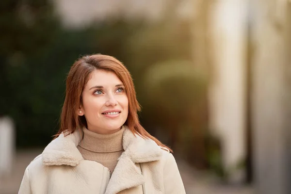 外を歩いていると 遠くを見て笑っている女性のクローズアップ — ストック写真