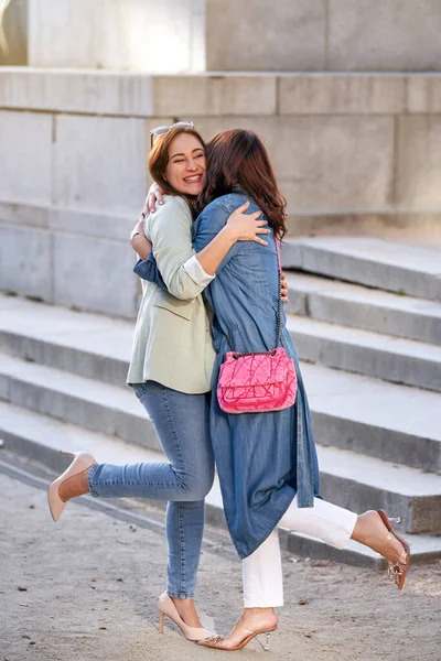 路上で屋外で会う間に抱き合っている2人の女性の友人 友情の概念 — ストック写真