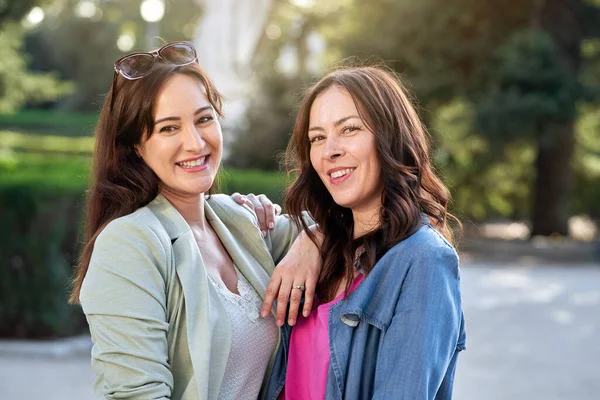 屋外で一緒にポーズをとりながらカメラを見て微笑む2人の女友達 友情の概念 — ストック写真