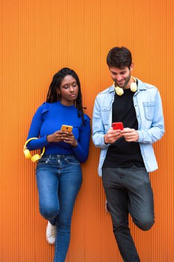 Kadın ve erkek renkli duvara karşı cep telefonu kullanıyor. Teknoloji konsepti.