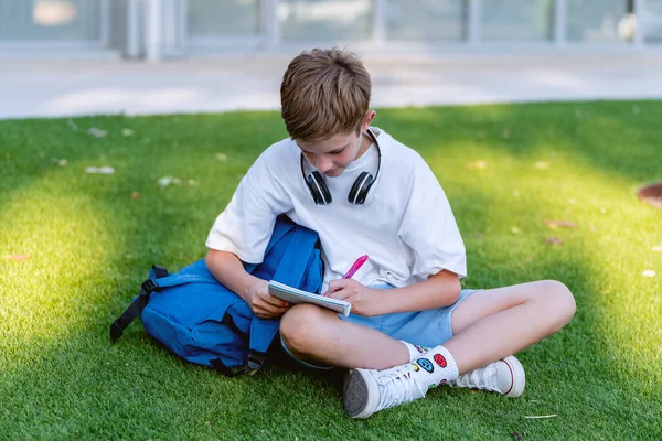 Εφηβικό Αγόρι Κάνει Σχολική Εργασία Ένα Σημειωματάριο Ενώ Κάθεται Στο — Φωτογραφία Αρχείου