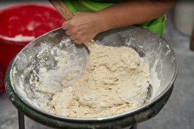 Çurros yapmak için çubukla hamur karıştıran bir aşçının yakın çekimi. Tipik İspanyol kahvaltısı. 