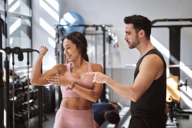 Spor salonunda spor yaptıktan sonra spor salonundaki antrenörüne kaslarını gösteriyor. Spor konsepti.