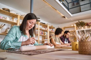 Çömlek atölyesinde kille çalışan bir kadın. El işi ve hobi konsepti.