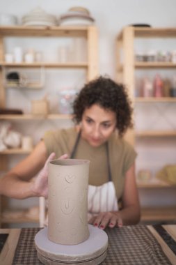 Çömlekçi kadın atölyesinde el yapımı seramik bir parça yapıyor. El işi ve hobiler konsepti.