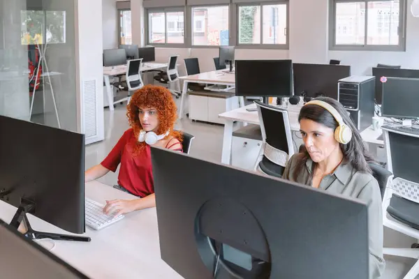 Duas Mulheres Com Fones Ouvido Trabalhando Intensamente Computadores Escritório Moderno — Fotografia de Stock
