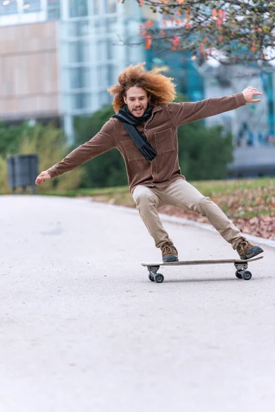 Dynamic young skateboarder glides along a city pathway, his balance and control evident in his focused yet carefree expression