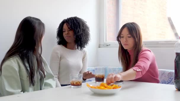 一个女人吃着辛辣的小吃 而她的朋友在她轻松愉快的时候嘲笑她的反应 — 图库视频影像