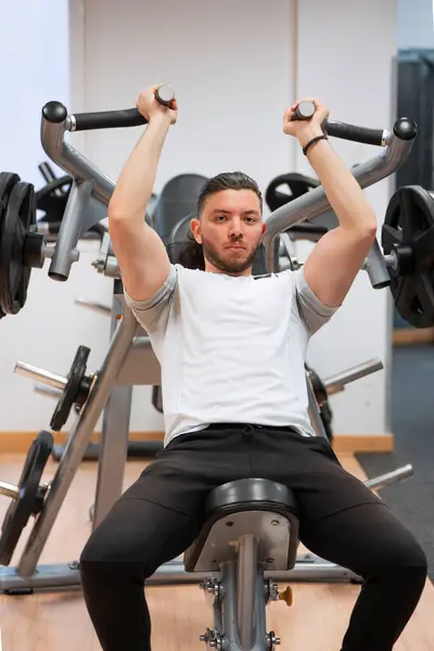 Konzentrierter Mann Weißen Shirt Bei Einer Schulterpresseübung Einem Fitnesscenter lizenzfreie Stockbilder