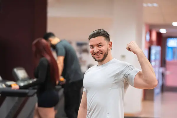 Muskulöser Mann Weißem Shirt Beugt Seinen Bizeps Vor Fokussierte Gymnastikbesucher Stockbild