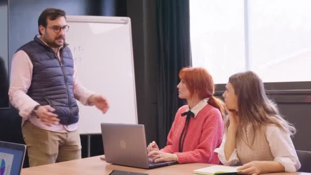 Manager Rügt Zwei Besorgte Mitarbeiterinnen Bei Einer Besprechung Mit Whiteboard — Stockvideo