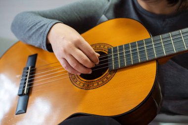 Close up of a musicians hands playing an acoustic guitar, demonstrating the art of music creation clipart