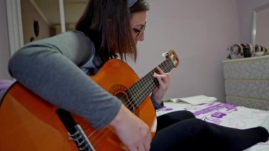 Akustik gitar çalan kadın, müzik yaratmada beceri ve tutkuyu vurgulayan çeşitli perspektifler sergiliyor