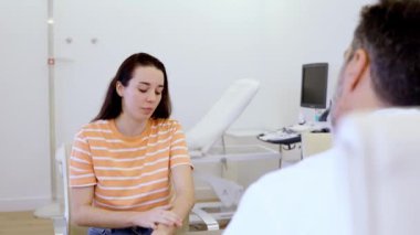 Kadın hasta, klinik ortamlarda detaylı tıbbi danışmanlık sırasında ilgili tıbbi uzmanlarla kişisel sağlık sorunlarını tartışıyor.