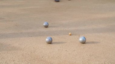 Fransız Petanque oyununda küçük ahşap Cochonnet ile kumlu arazide uzanan gümüş bulvarlar. 