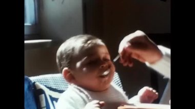 Trento, İtalya Nisan 1970: 70 'lerde bir anne bebeği bebek arabasında besliyor.