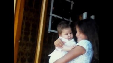 Napoli, İtalya Haziran 1980: 80 'lerde kucağında yeni doğmuş bir bebekle küçük bir kız