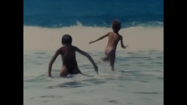 イタリアのナピリ1980年5月 80年代の波の中で海で遊ぶ子供たち — ストック動画