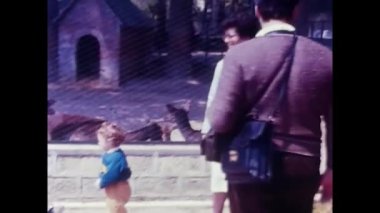 Palermo, İtalya, Mart 1970: Çocuklu anne hayvanat bahçesinde 70 'lerde kafeslenmiş hayvanlarla.