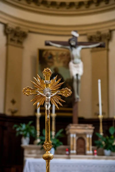 stock image detail of a golden crucifix with jesus behind placed at the altar of a church