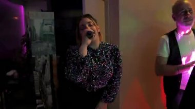 Terni, İtalya 16 Aralık 2022: Kadın vokalist dans kulübünde şarkı söyleyerek insanları eğlendiriyor