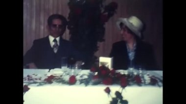 palermo, italy december 1970: married couples at a restaurant table in the 70s